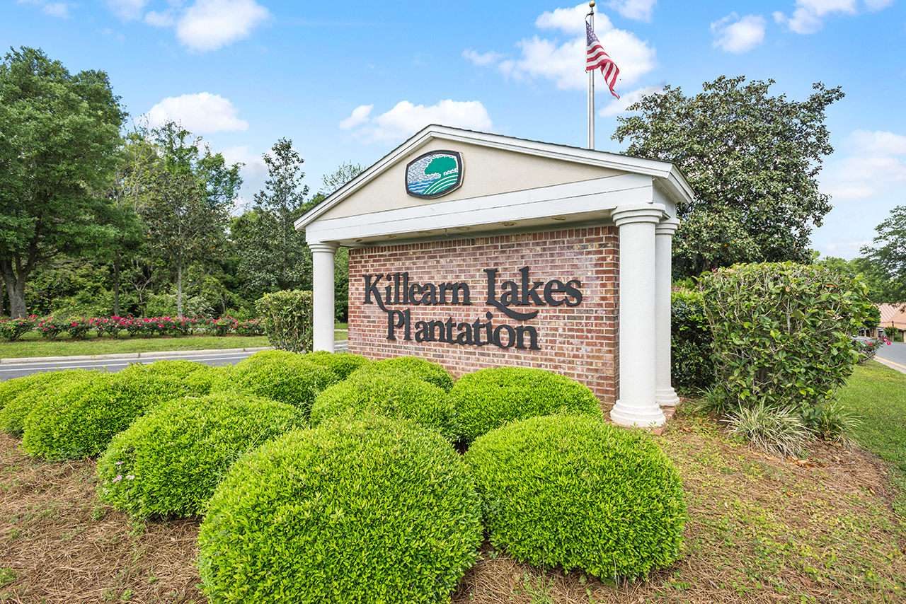 Killearn Lakes Plantation neighborhood entrance sign with flag in background