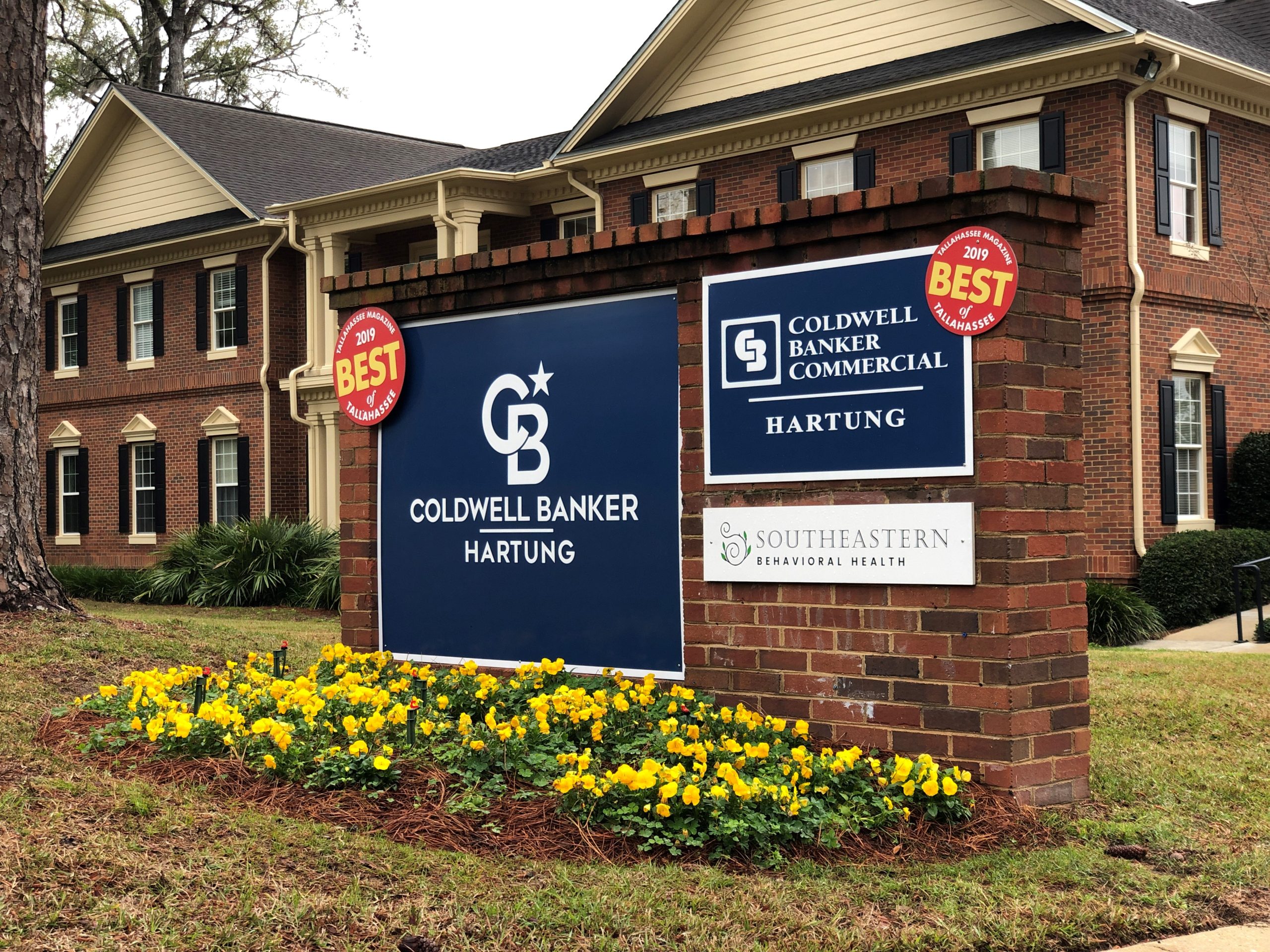 Red brick business sign for Coldwell Banker Hartung's Tallahassee office